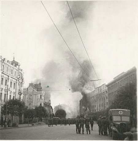 24.09.1941 р. Німецькі солдати та офіцери спостерігають за пожежею з боку площі Калініна (Майдану Незалежності). Ліворуч – будівля колишньої Біржі, далі – наріжна будівля на вулиці К.Маркса (нині Городецького). З правого боку – пожежа будівлі довоєнного поштамту та 